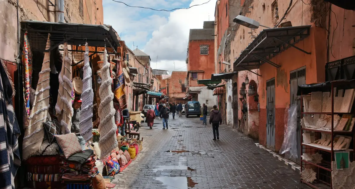 Een winkelstraat in Marrakech met kleden en stoffen