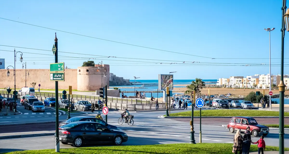Straatbeeld in Rabat met de oude stadsmuur en de zee op de achtergrond