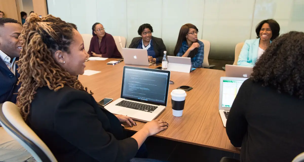 Collega's in overleg rond een tafel met laptops